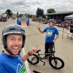 Go BIG BMX Air Show school assembly with two BMX riders, one wearing Harley-Davidson helmet, in front of students