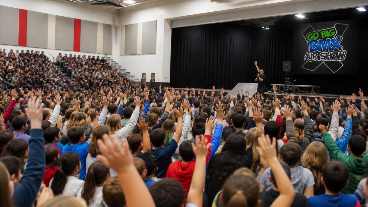 Students cheering at one of the best anti bullying school assembly programs in a gymnasium
